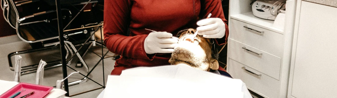 Dentist Wheeling IL Emergency Dentistry Focused a man is lying down in a dentist chair with a bright light on his face while receiving care